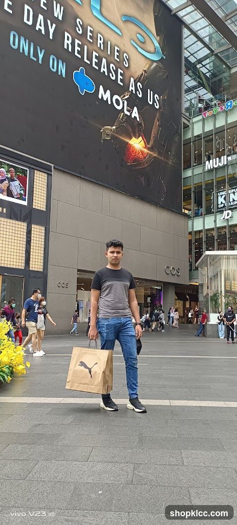 Man holding shopping bag in front of mall building