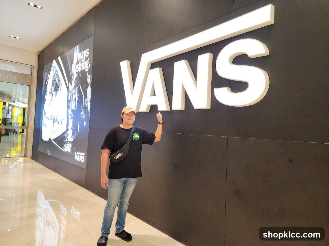 Man Posing in Front of Vans Store Sign