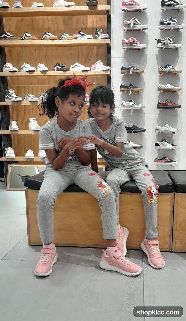 Two girls sitting in a shoe store