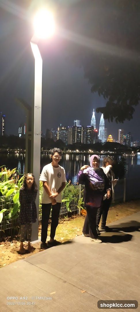 People by a lake at night with city skyline