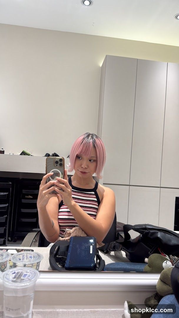 Woman taking a mirror selfie with pink hair