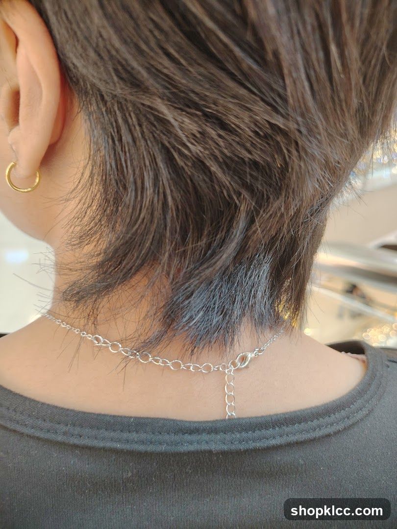Close-up of a person's neck and ear with jewelry