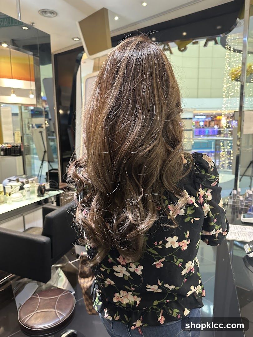 Woman with long, wavy brown hair in a salon