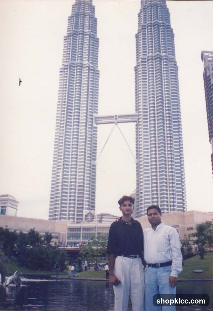 Two men posing in front of the Petronas Towers