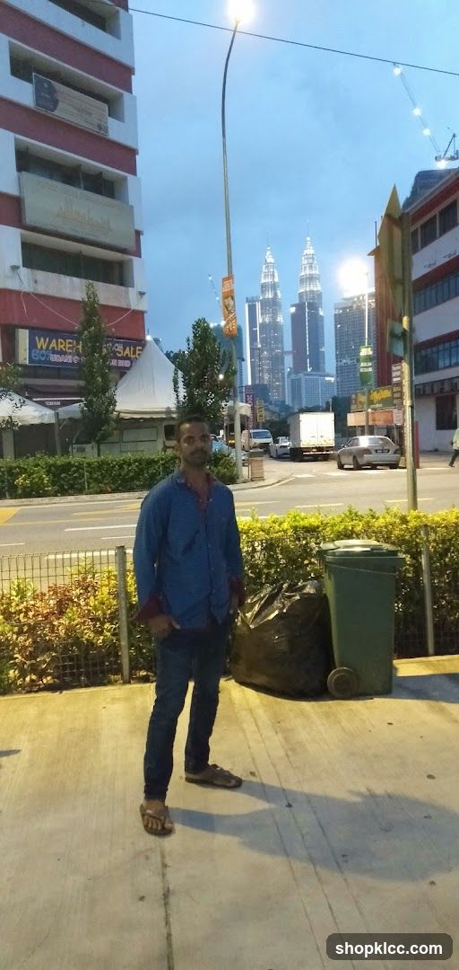 Man standing on sidewalk with city skyline in background