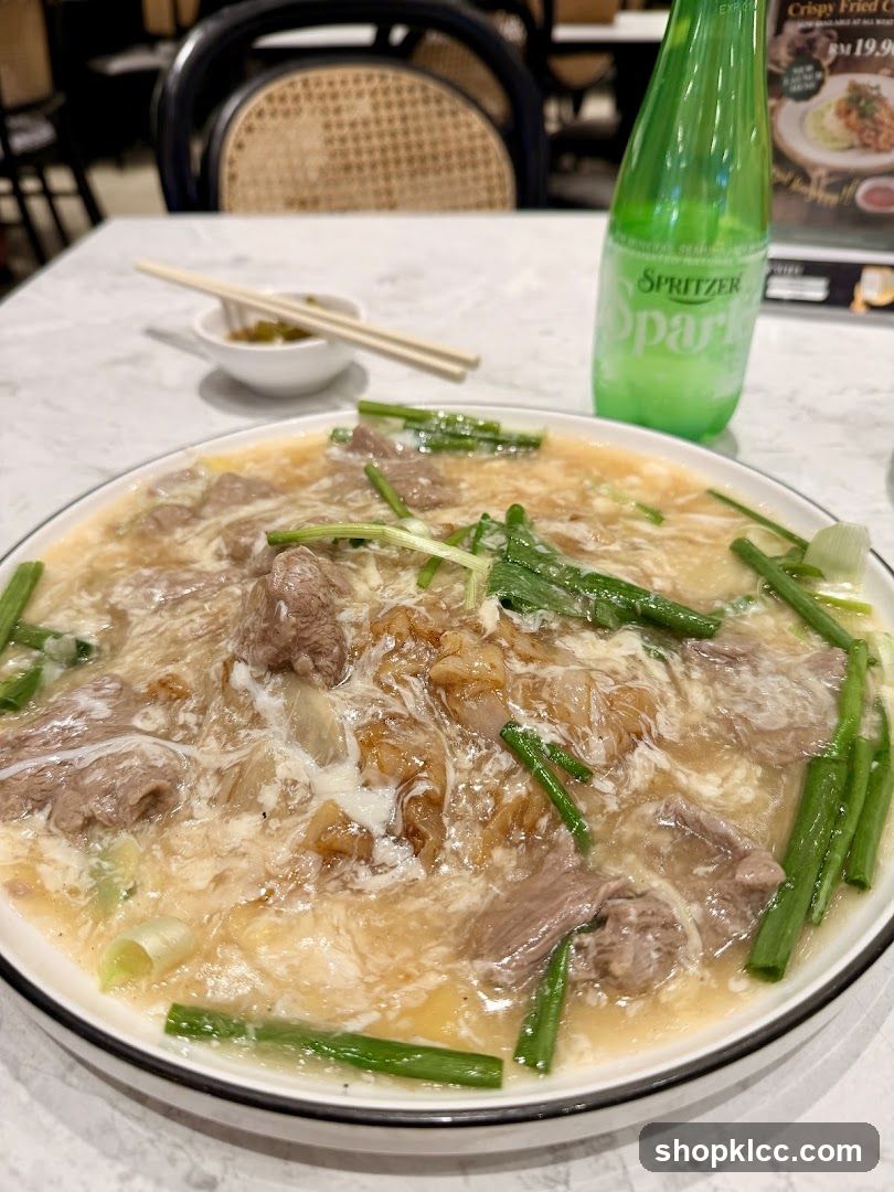 Beef noodle dish with a bottle of sparkling water