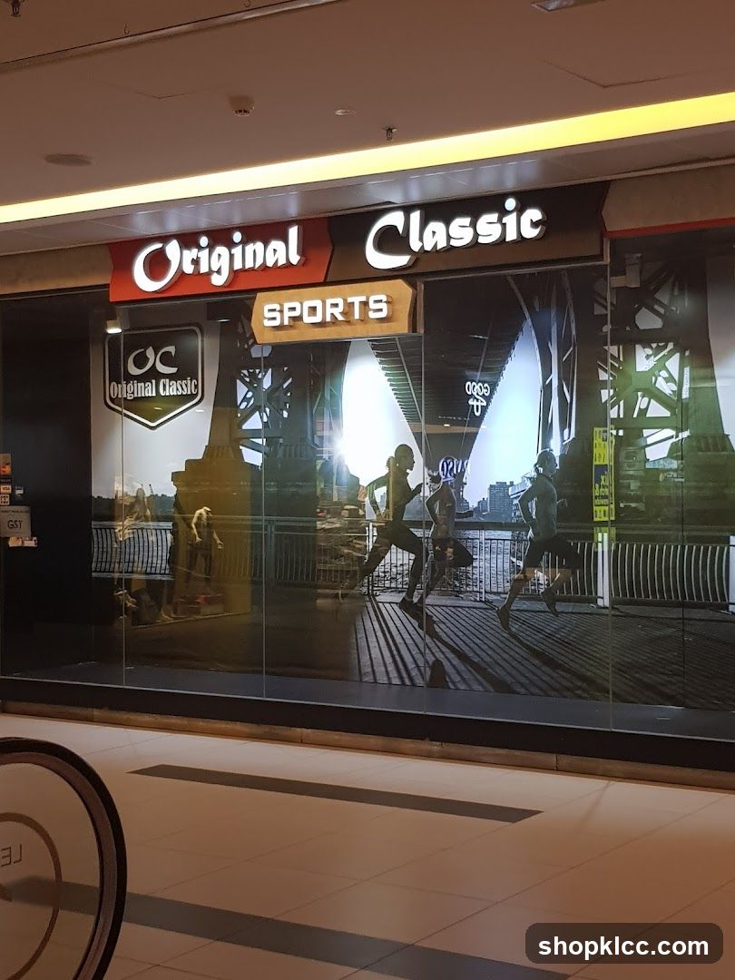 The storefront of a sports store named "Original Classic Sports". The name is displayed in large, illuminated letters above the entrance. The glass facade features a graphic of runners and a cityscape. A smaller "OC Original Classic" logo is visible on the left side of the entrance.