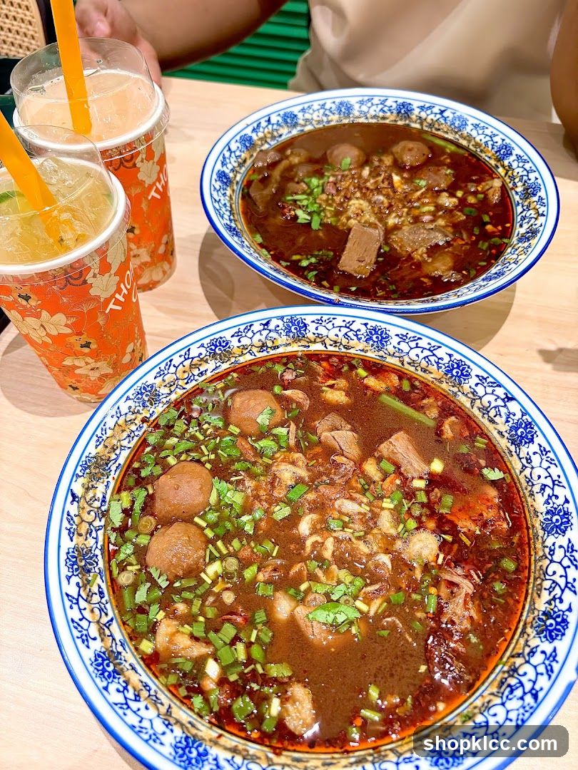 Two bowls of beef noodle soup and two drinks
