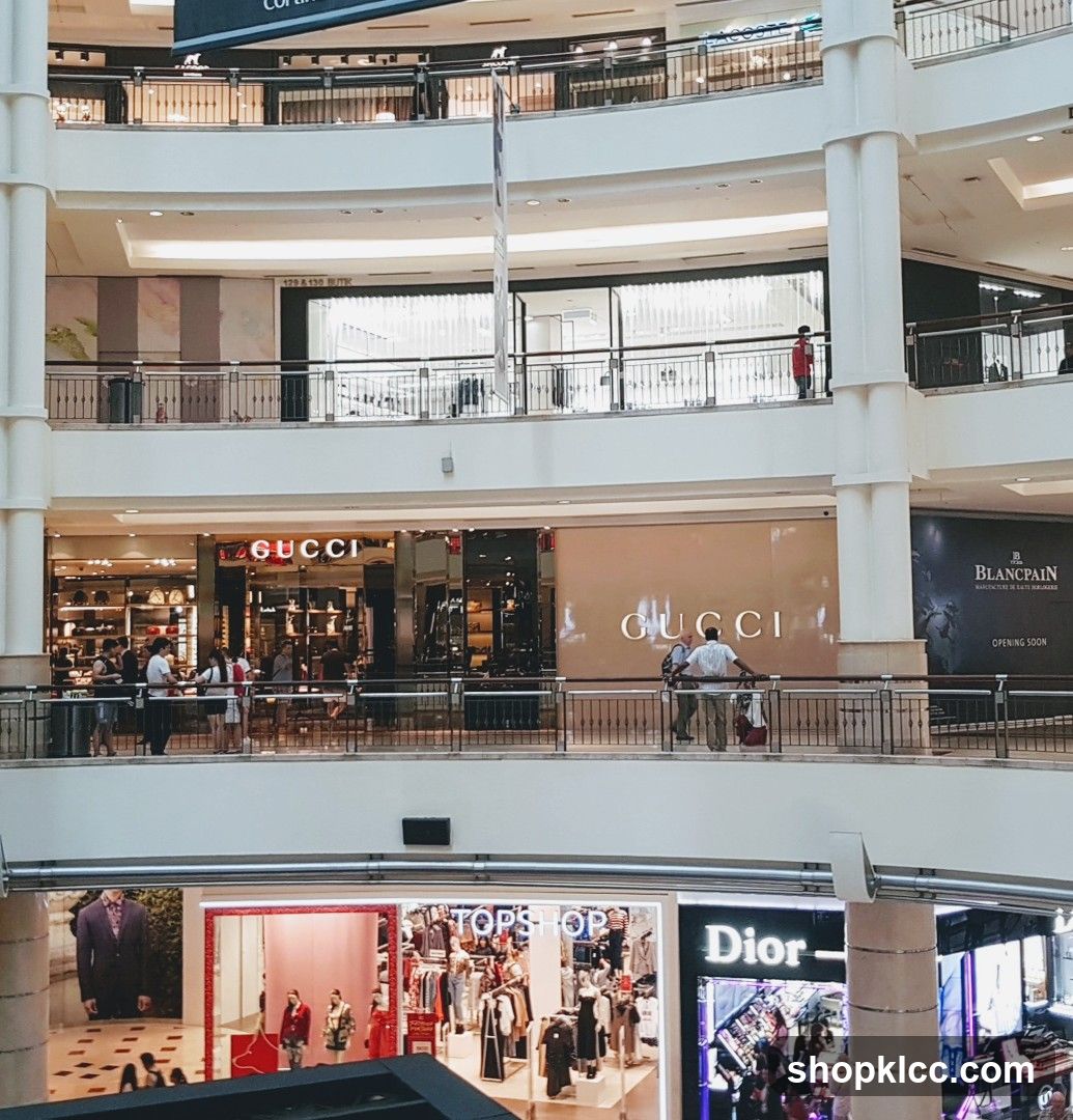 Multi-level shopping mall interior with various luxury brand stores