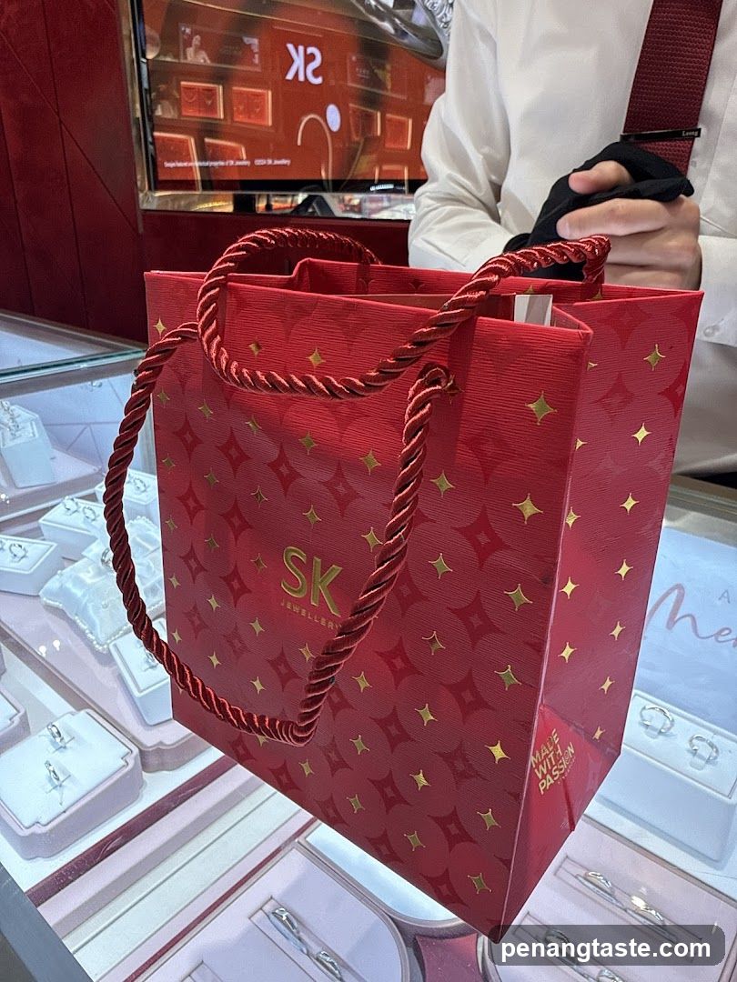 Red shopping bag with gold star pattern and SK JEWELLERY logo