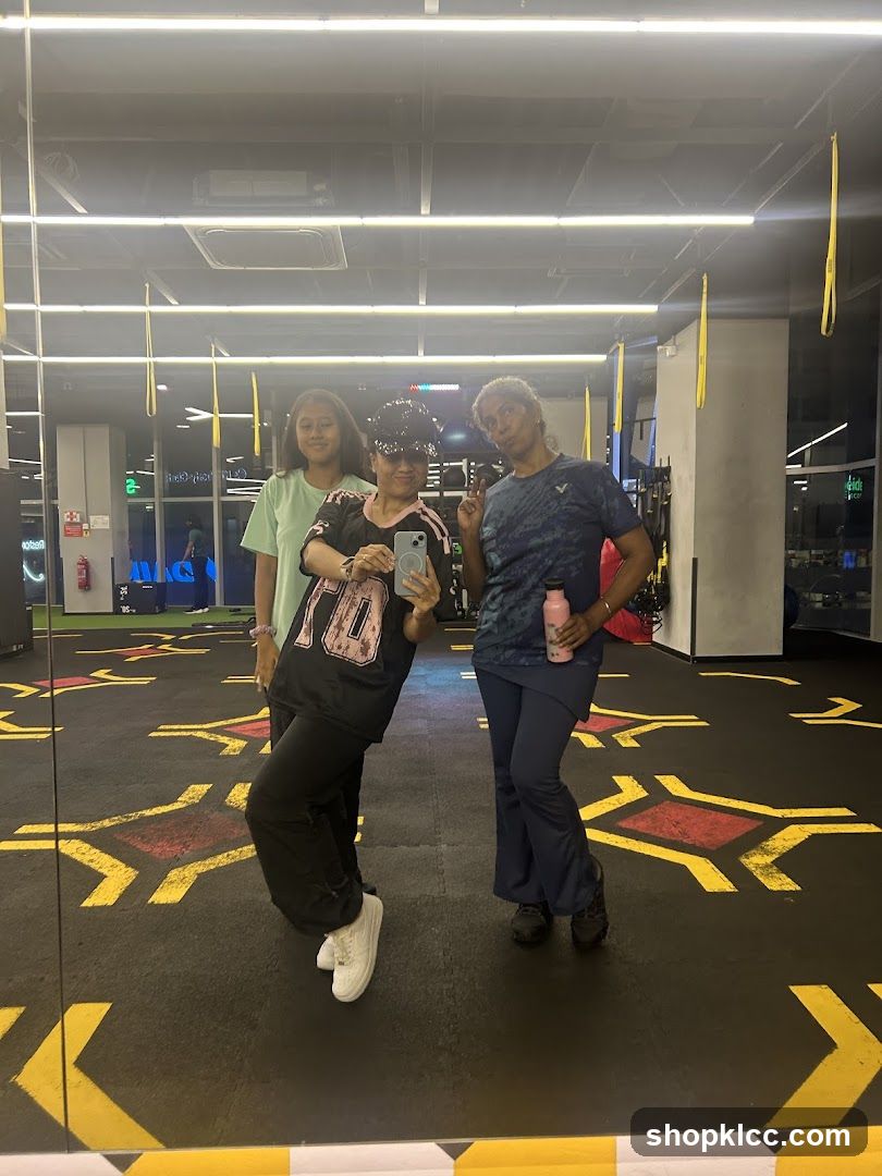 Three people posing for a mirror selfie in a gym