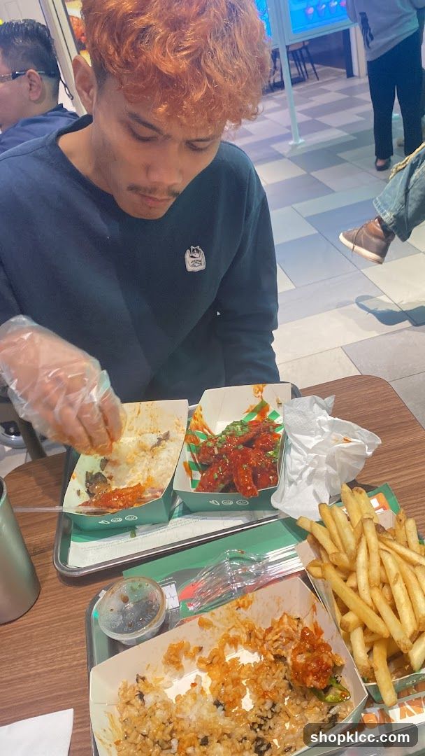 Person eating fried chicken and rice