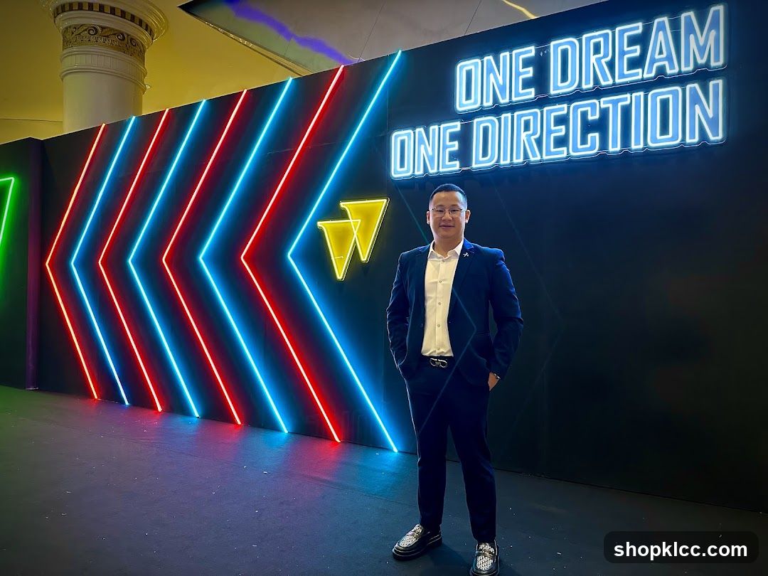 Man Poses in Front of Neon Wall