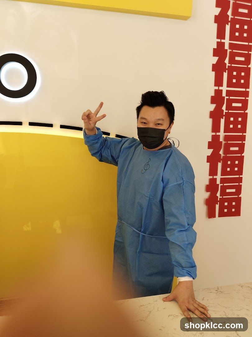 Person in blue protective gear making peace sign indoors