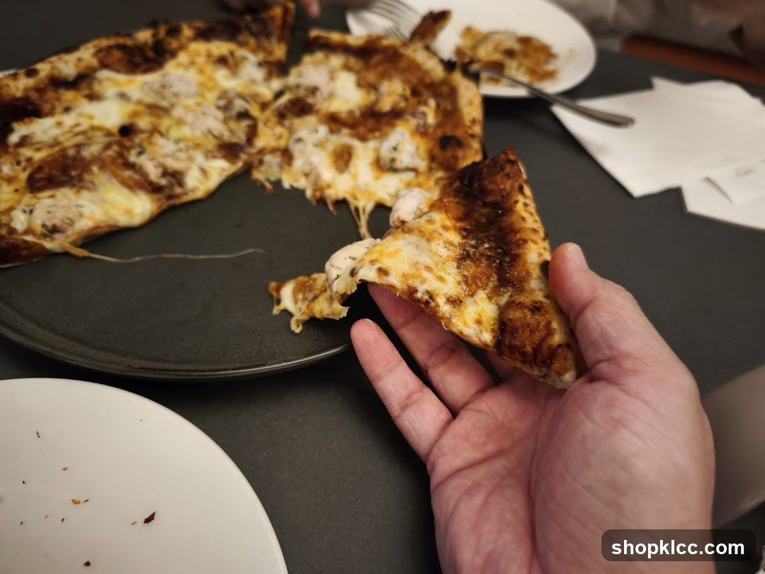 Pizza Slice Held in Hand