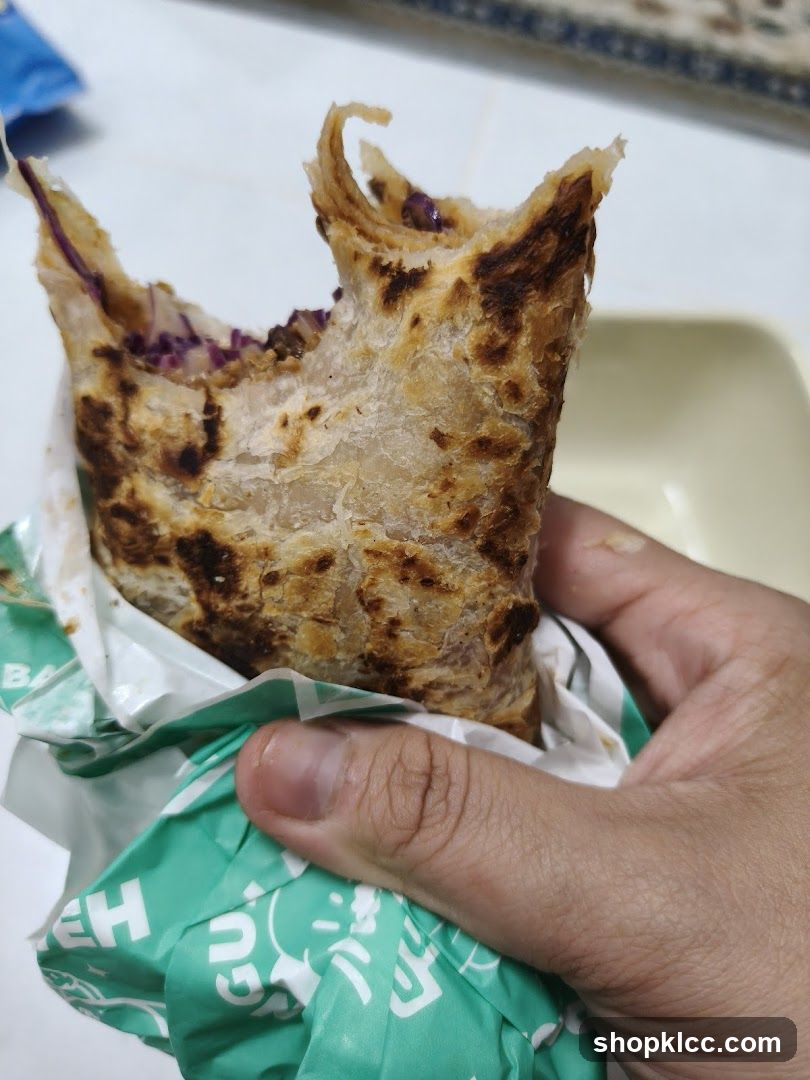 Hand holding a partially eaten wrap