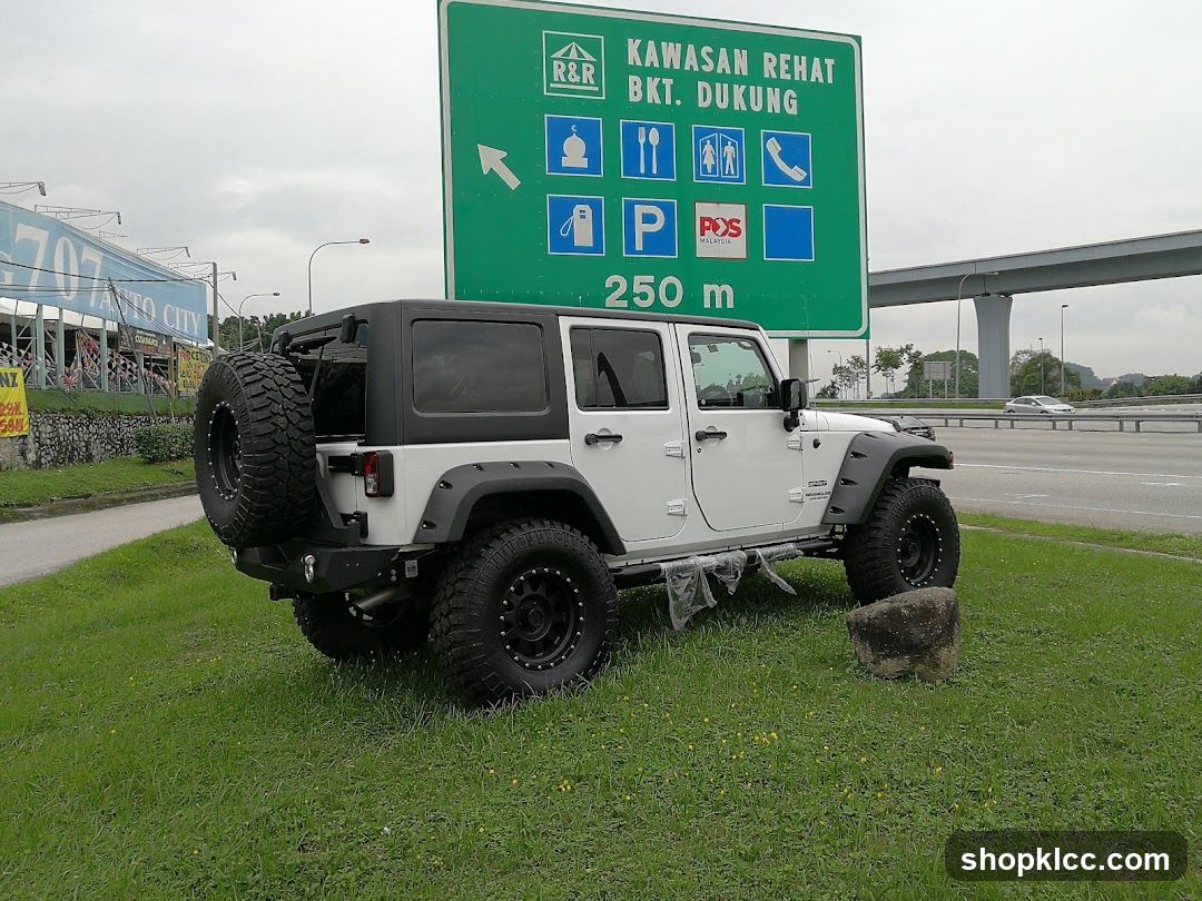 Jeep on grass near highway sign