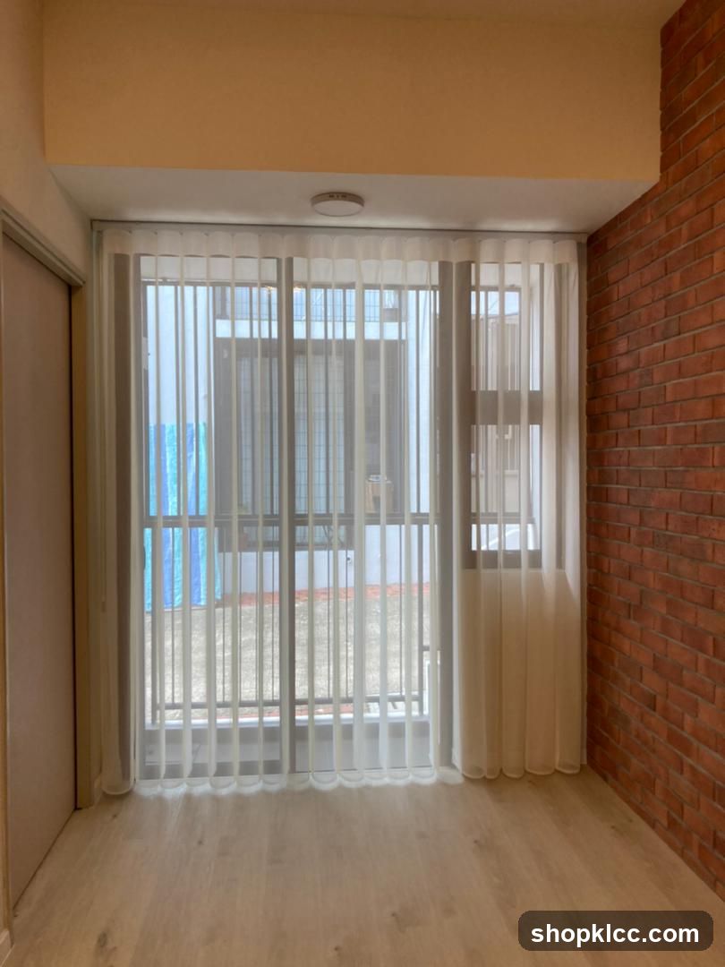 Interior with sheer curtains and brick wall