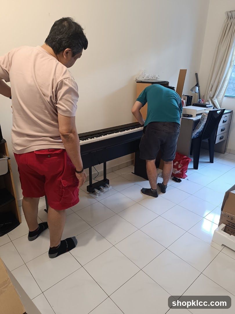 Two men assembling a digital piano in a room
