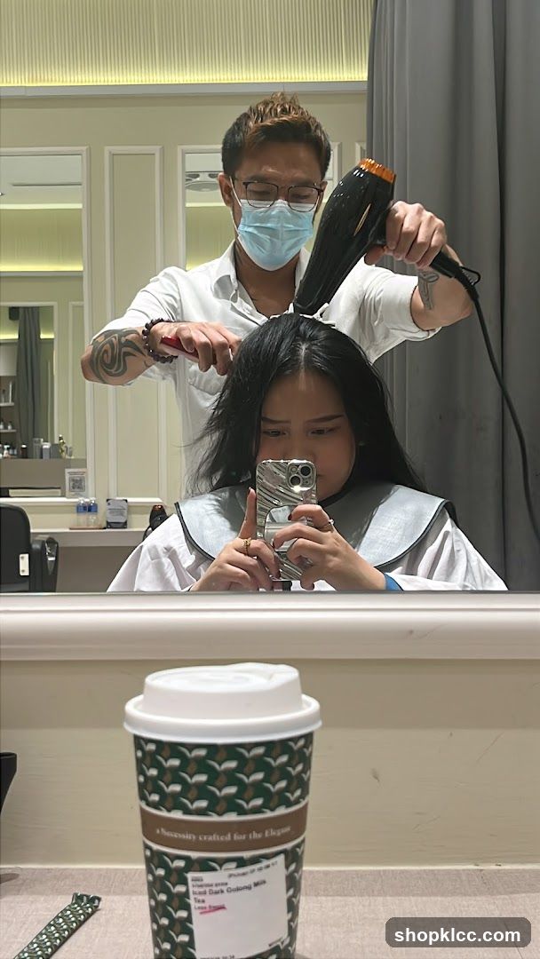 Hairdresser drying client's hair