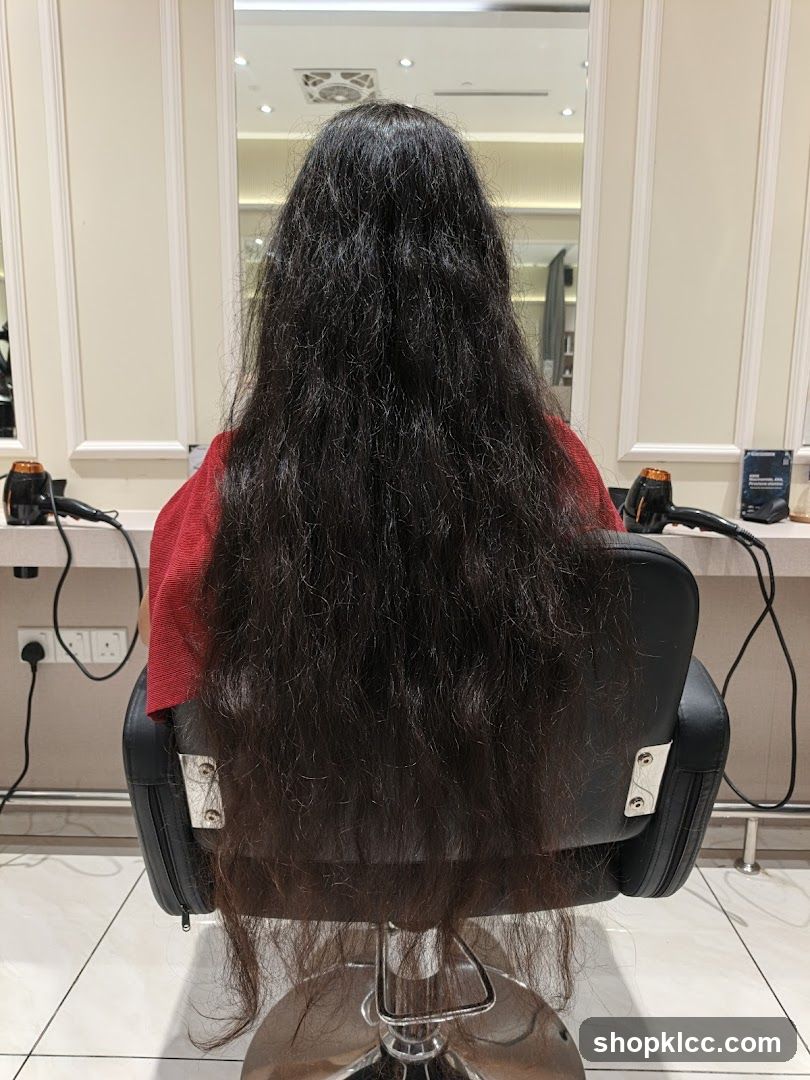 Woman with long dark hair sitting in a salon chair
