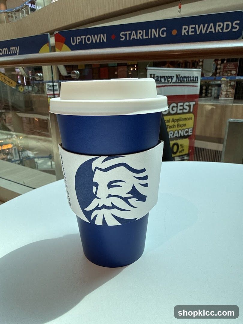 Coffee Cup with Harvey Norman Ad in Background