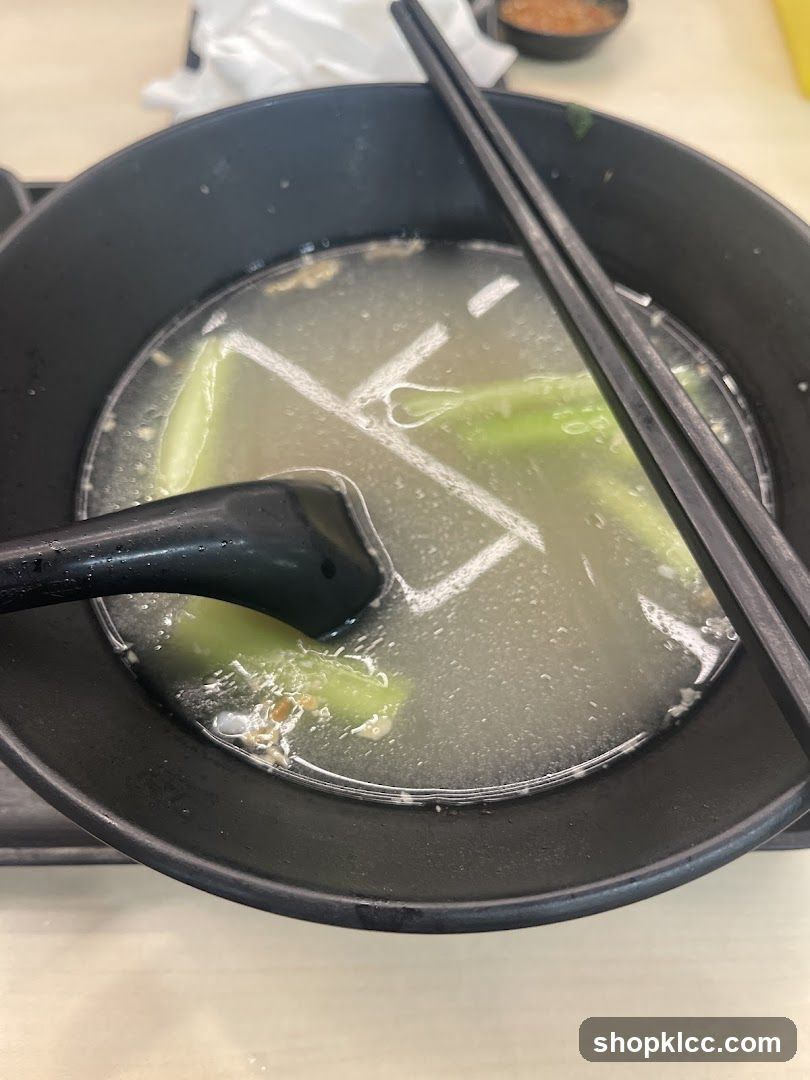 Bowl of Soup with Vegetables and Chopsticks