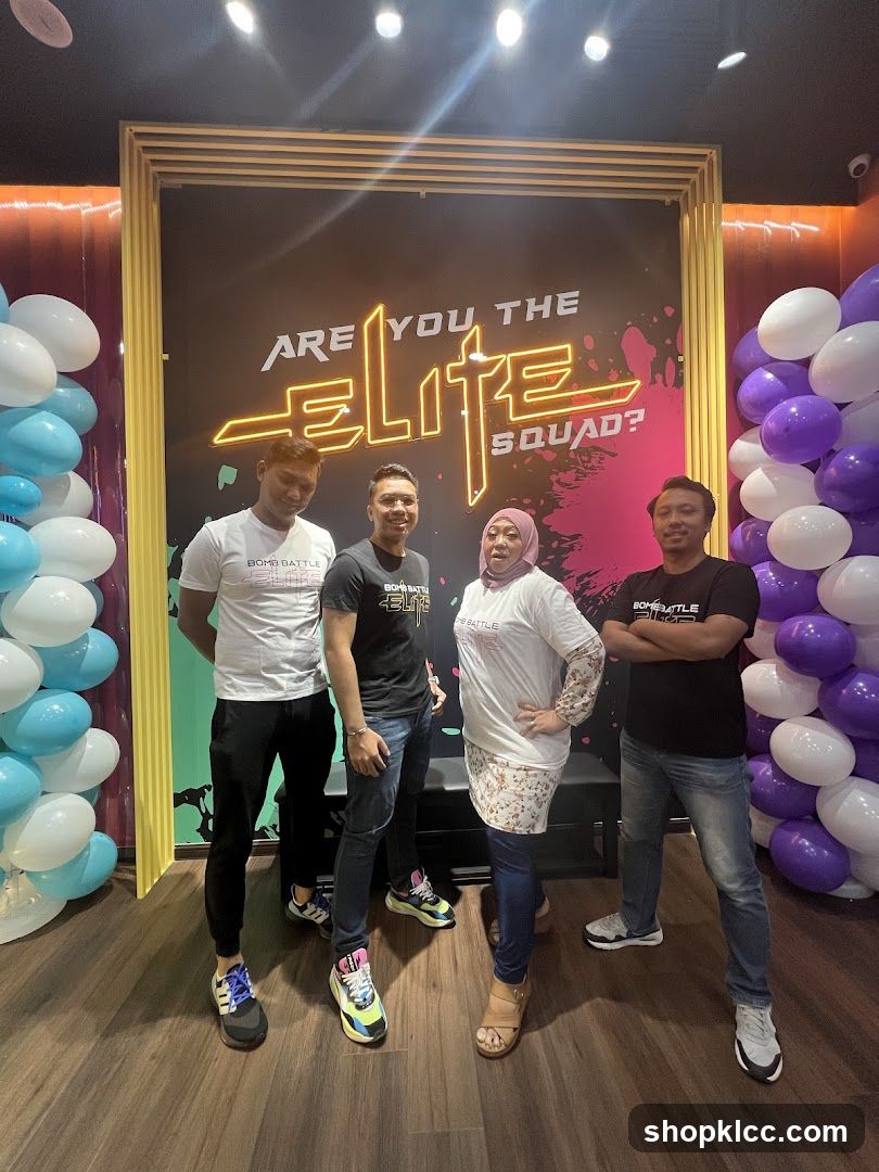Four people posing in front of a neon sign