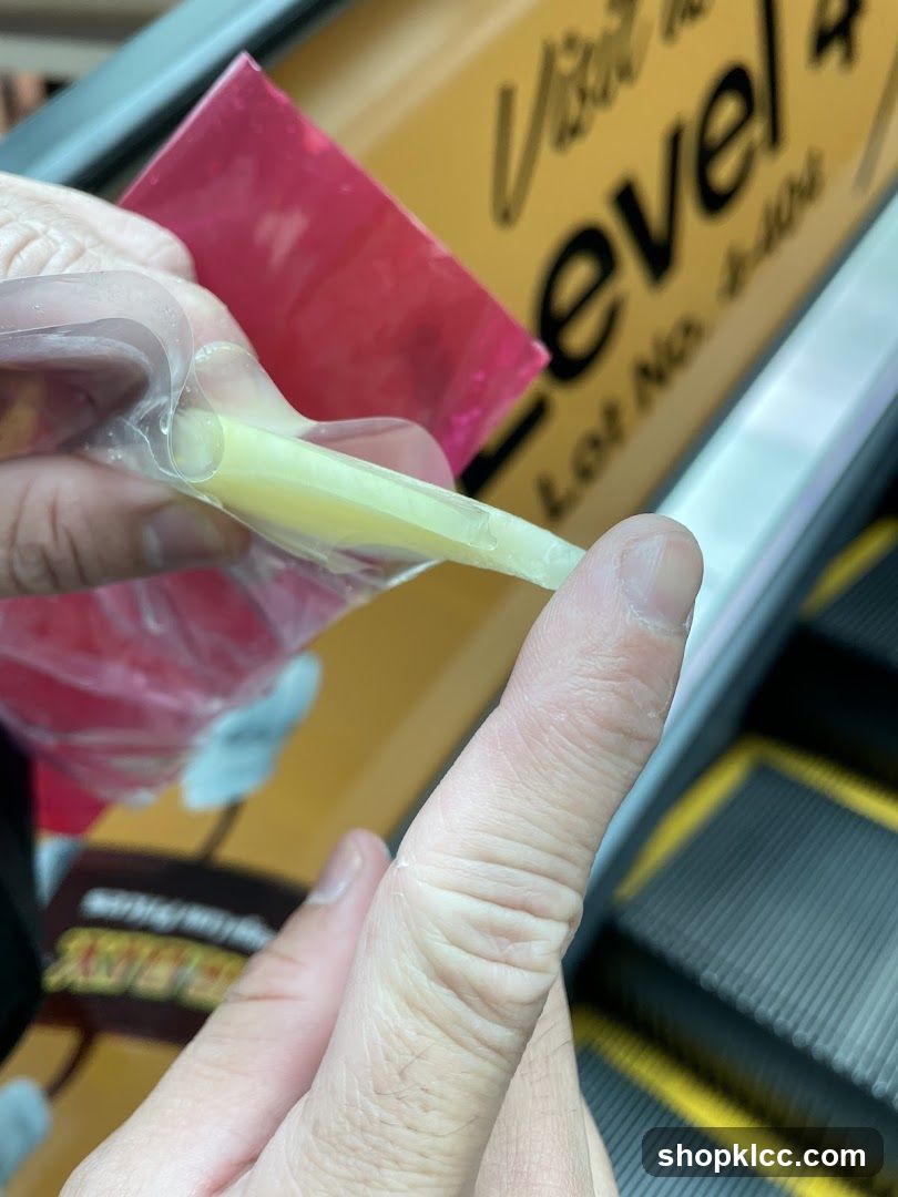 Hand holding a packaged food item near escalator