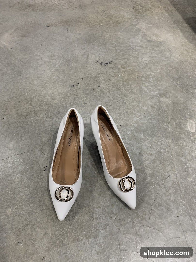 White pointed-toe pumps with decorative rings