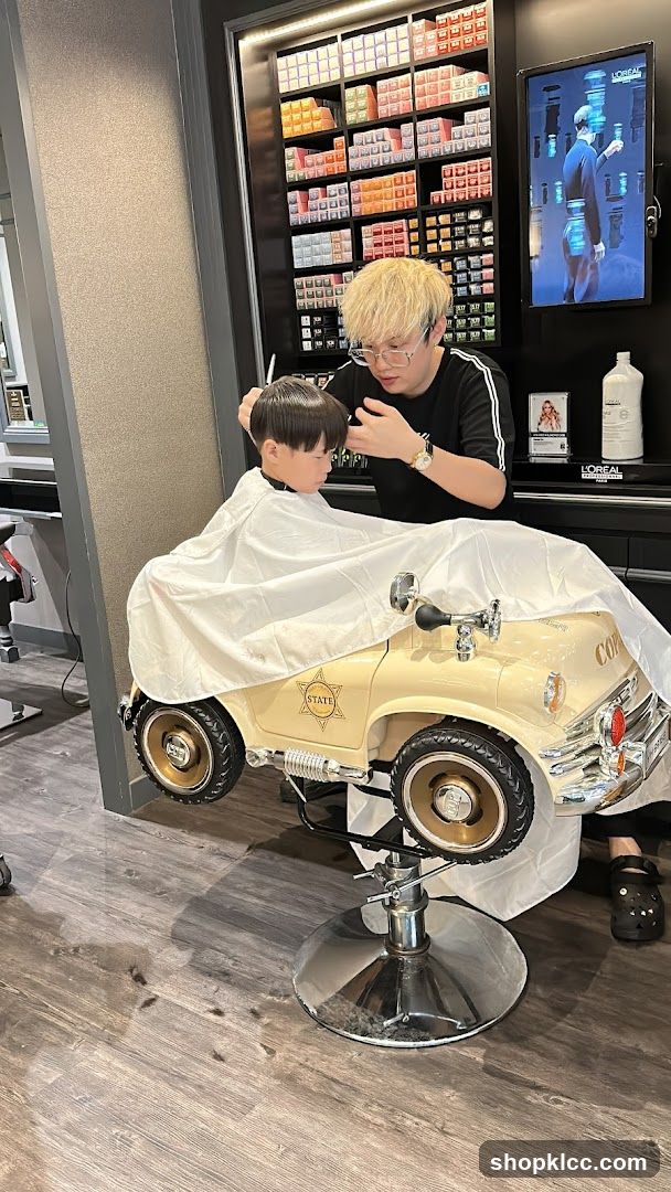 Barber cutting kid's hair in car chair