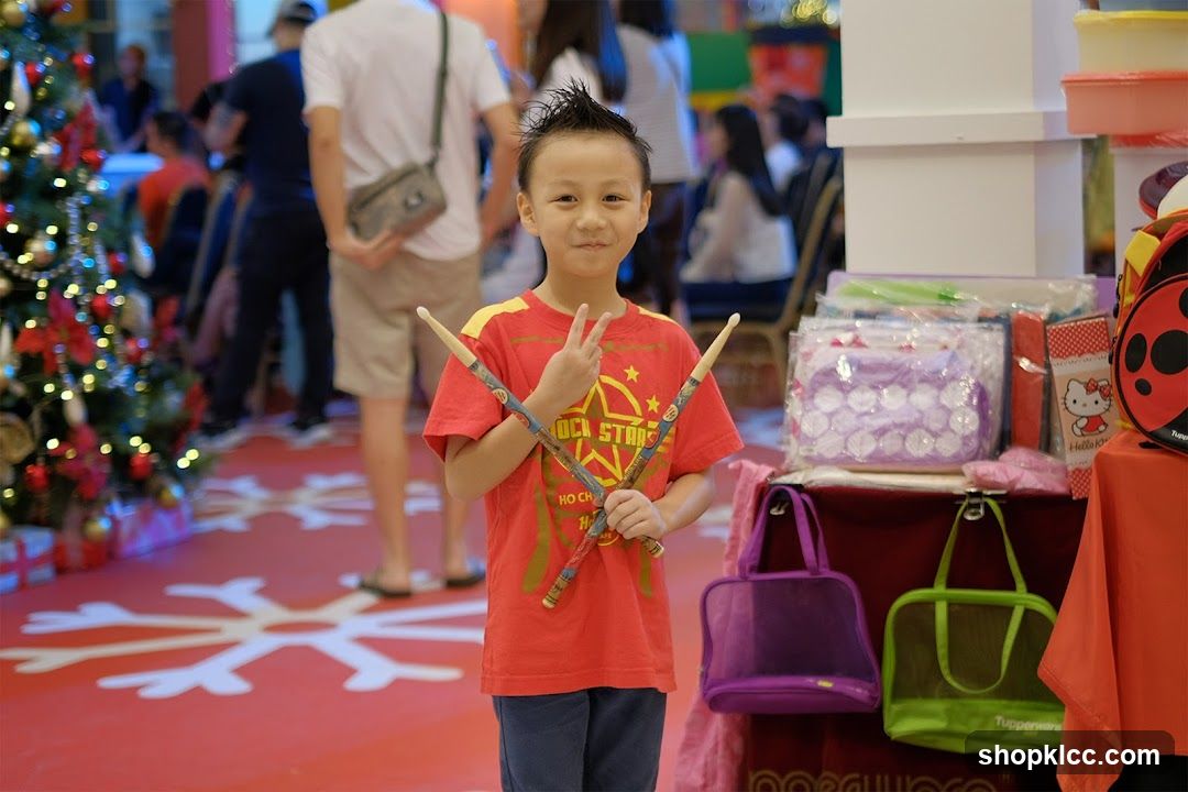 Child with drumsticks in mall
