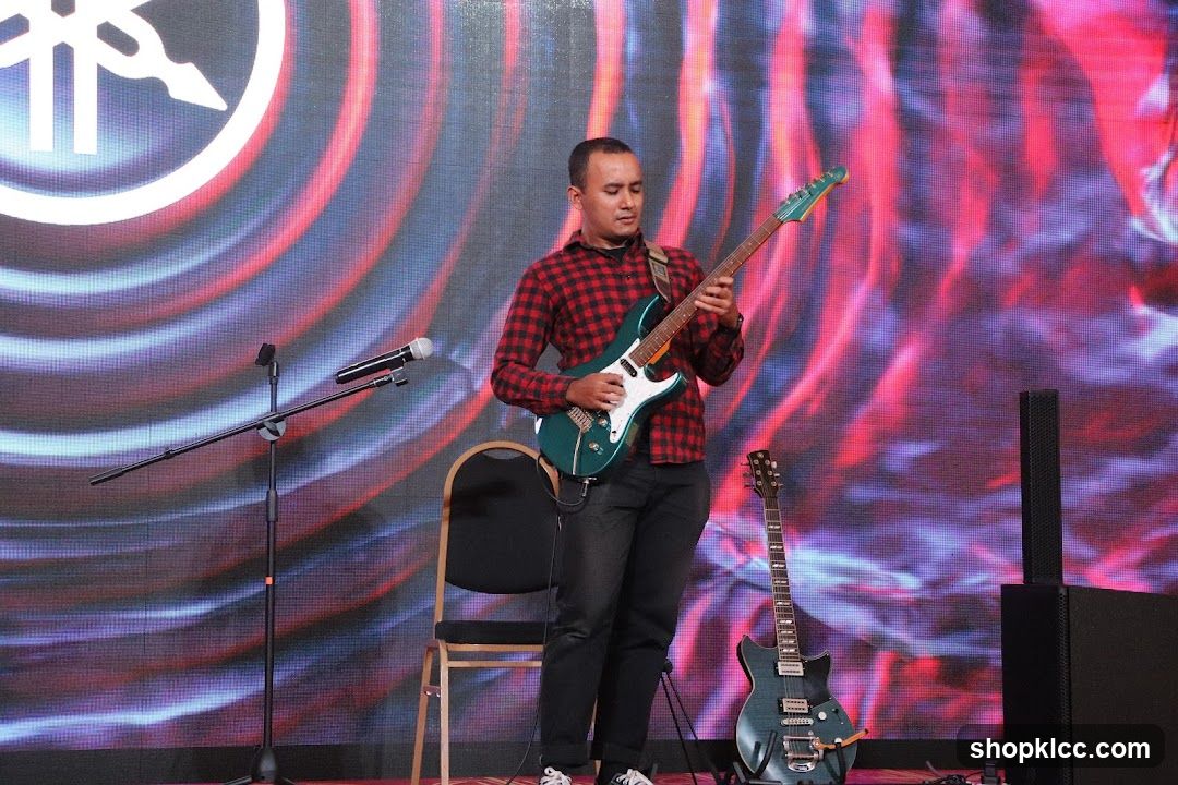 Guitarist on Stage with Yamaha Logo Background