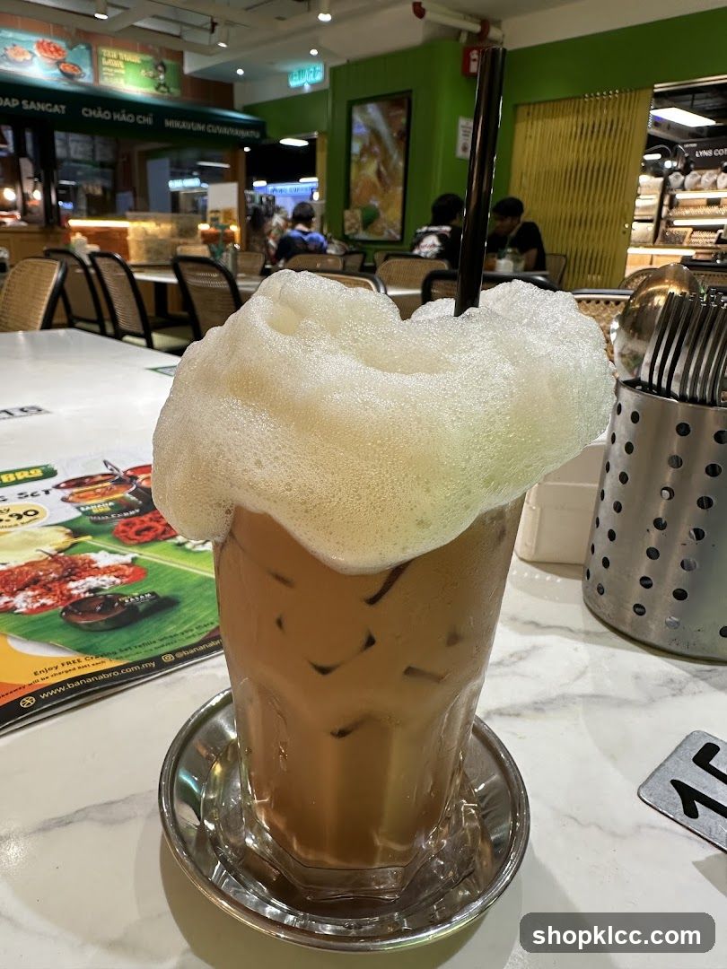 Iced Coffee with Foam in a Glass Cup