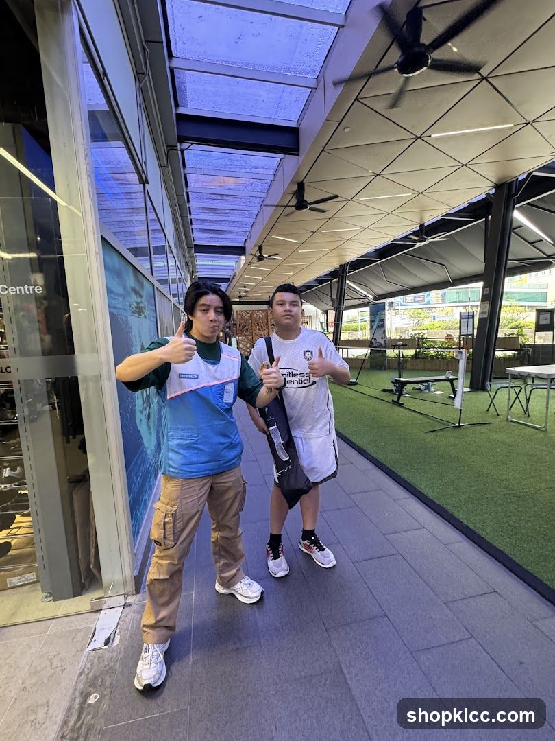 Two people posing outside a building