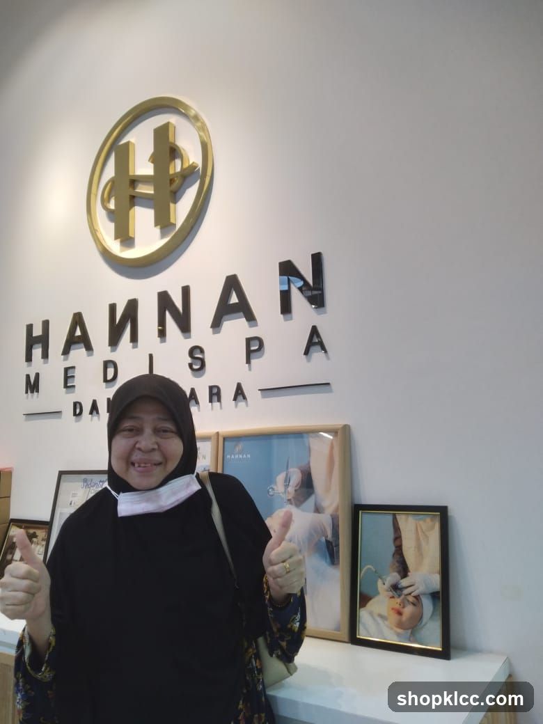 Woman giving thumbs up in front of spa sign