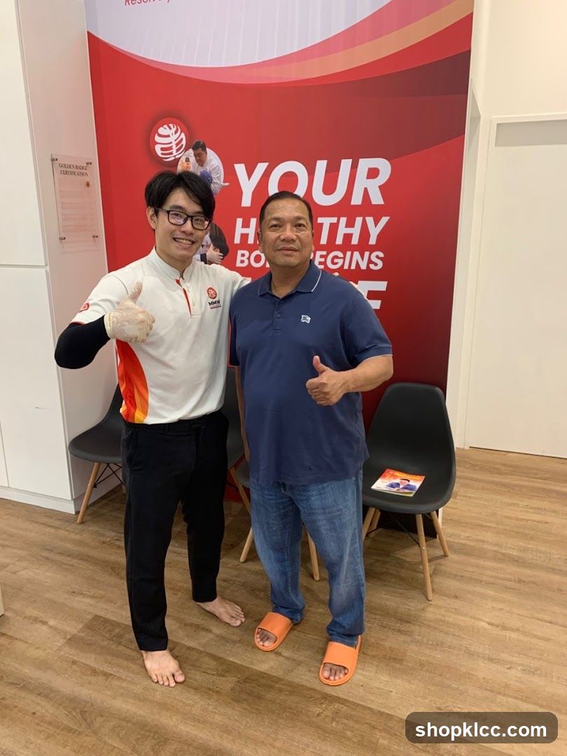Two men giving thumbs up in front of a health promotion banner