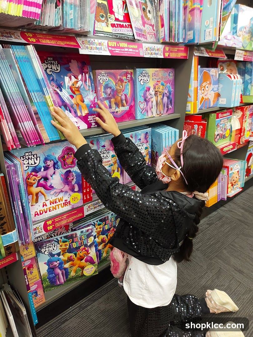 Child selecting My Little Pony books in store aisle