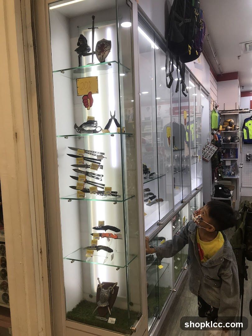 Display case with knives and a child looking