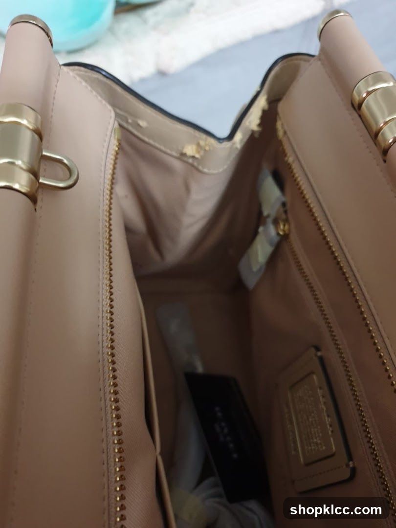 Interior of a beige handbag with visible wear