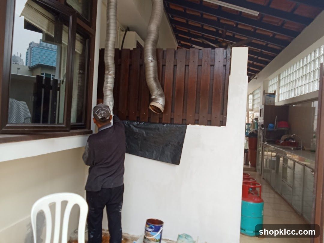 Worker installing ventilation ducts on building exterior