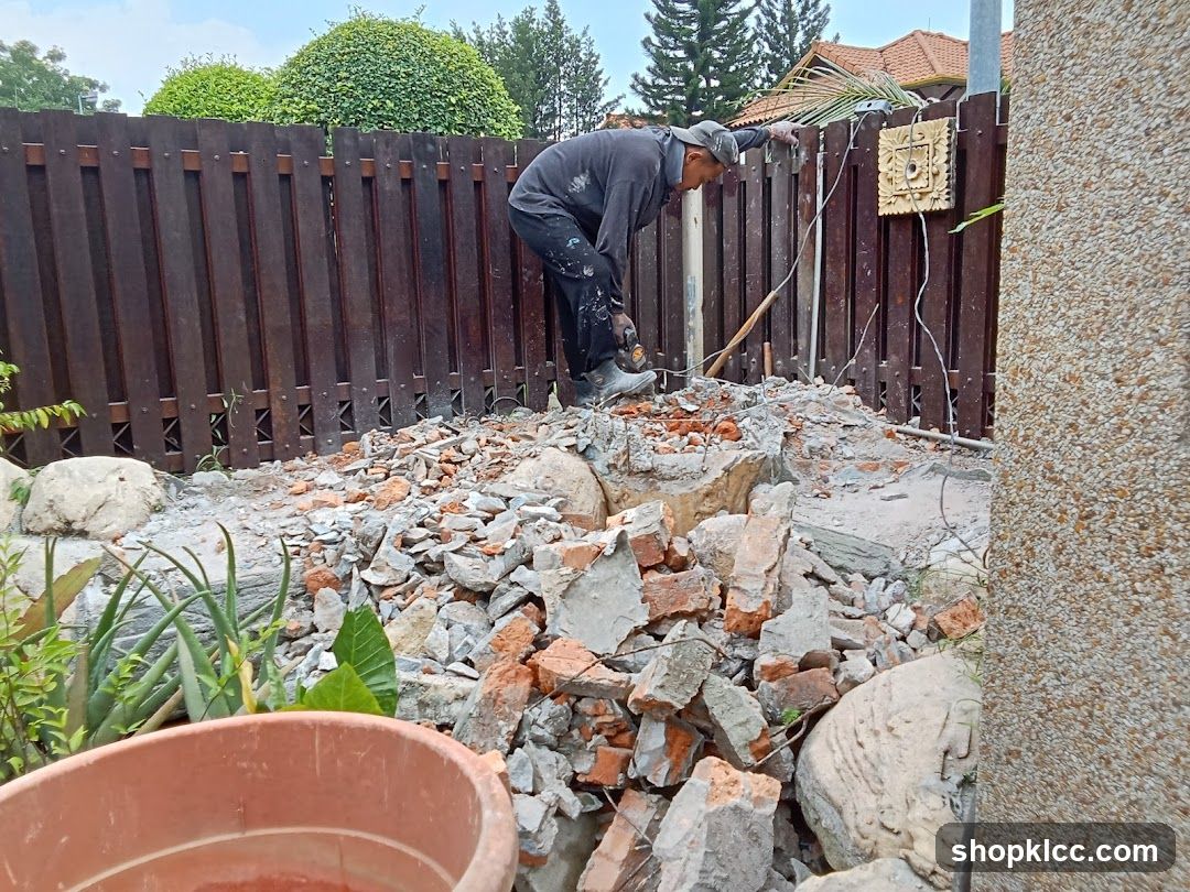 Worker demolishing fence and wall