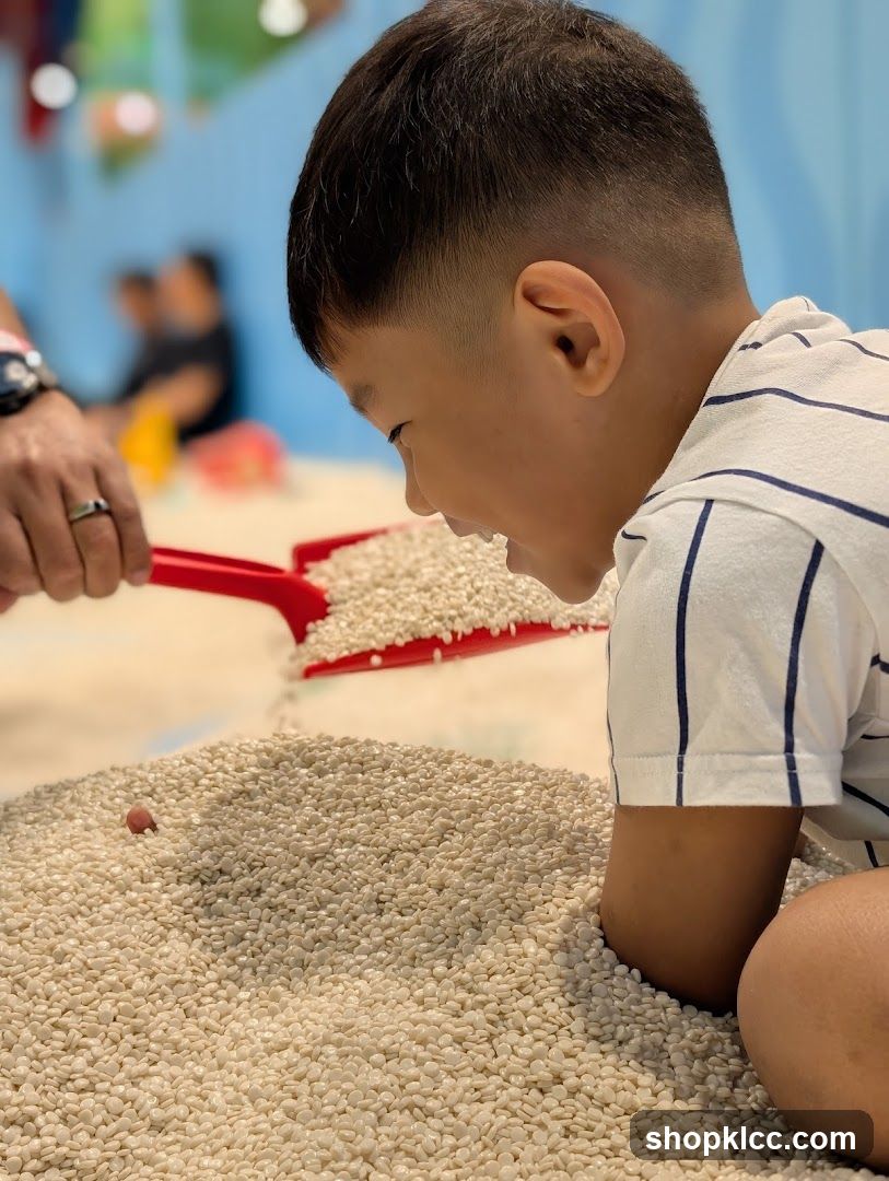 Child Playing with Rice in Indoor Sandpit