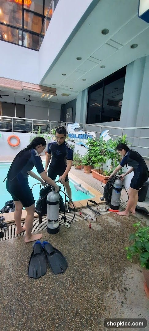 Divers preparing gear by pool