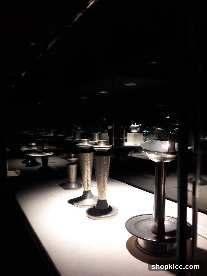 Display of metallic candlesticks in a dimly lit room