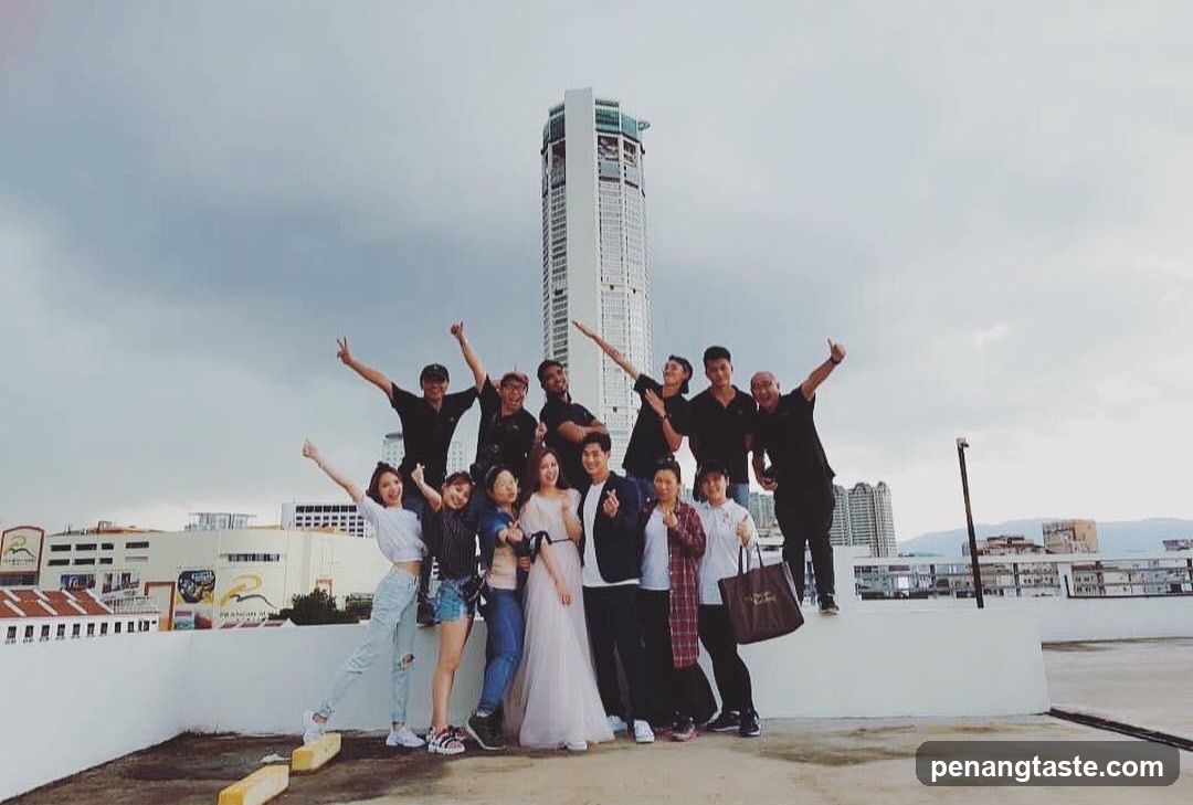 Group posing on rooftop with cityscape