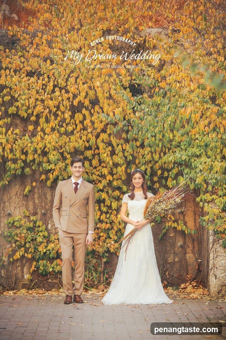 Wedding Couple Posing in Front of Autumn Foliage