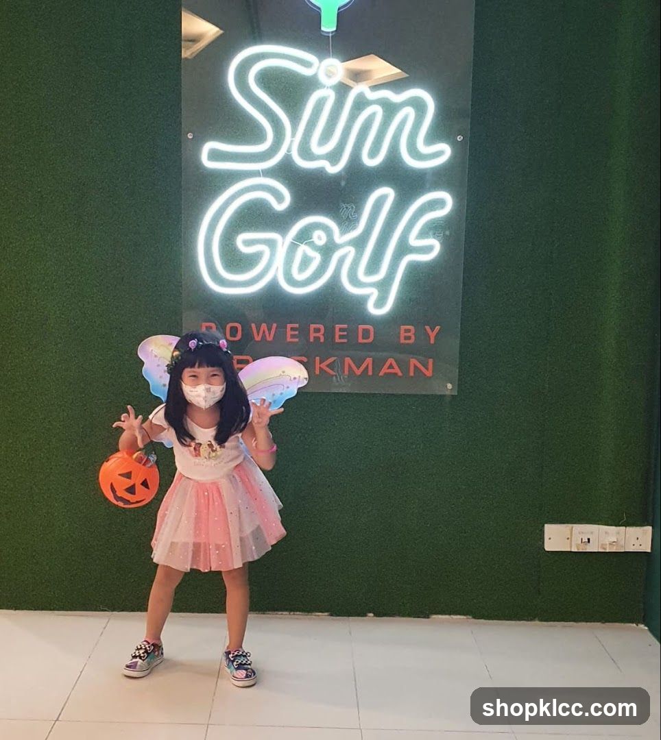 Child in costume posing with pumpkin