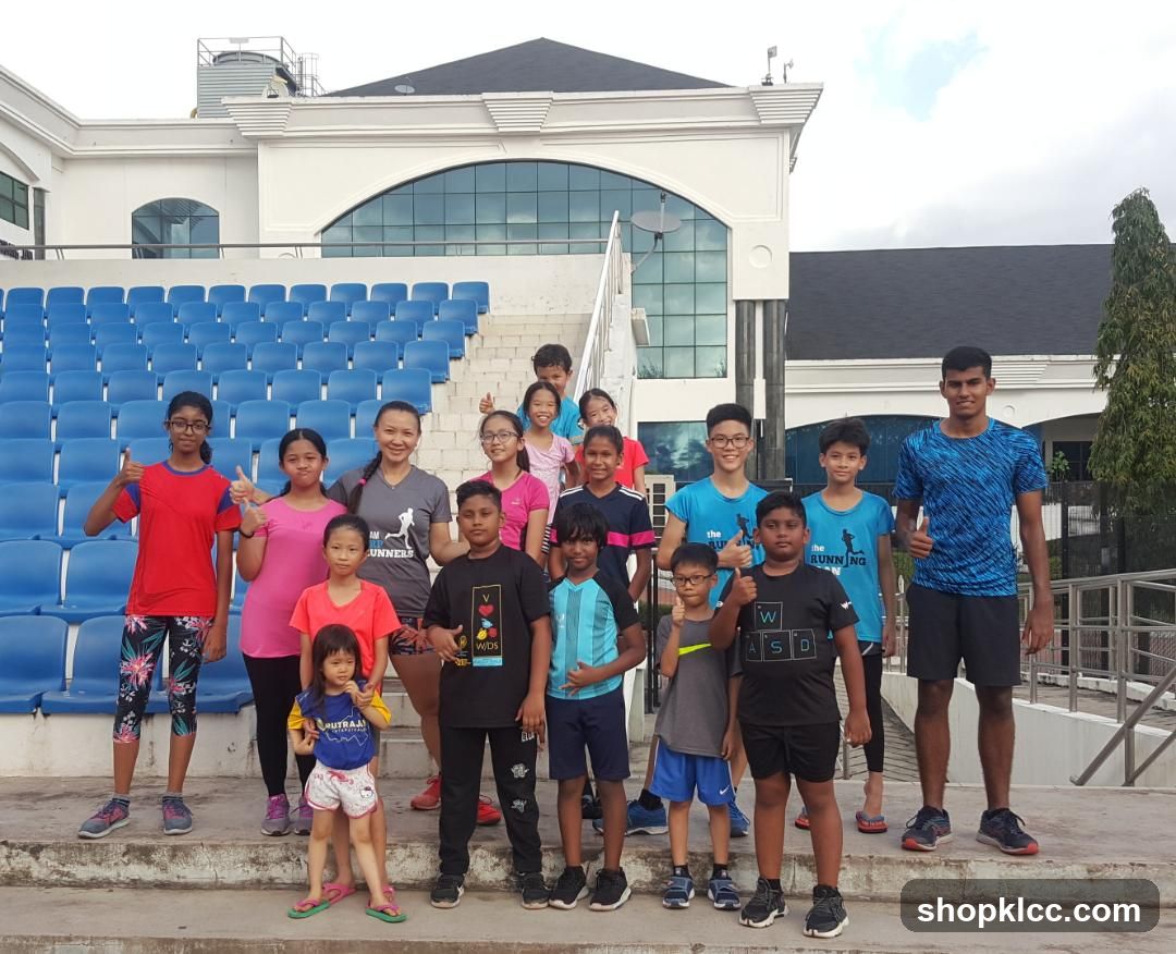 Group of children and teens posing in front of a stadium