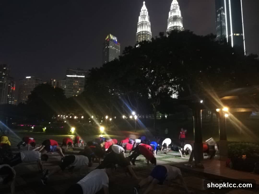 Nighttime Group Exercise in Park with Petronas Twin Towers Background